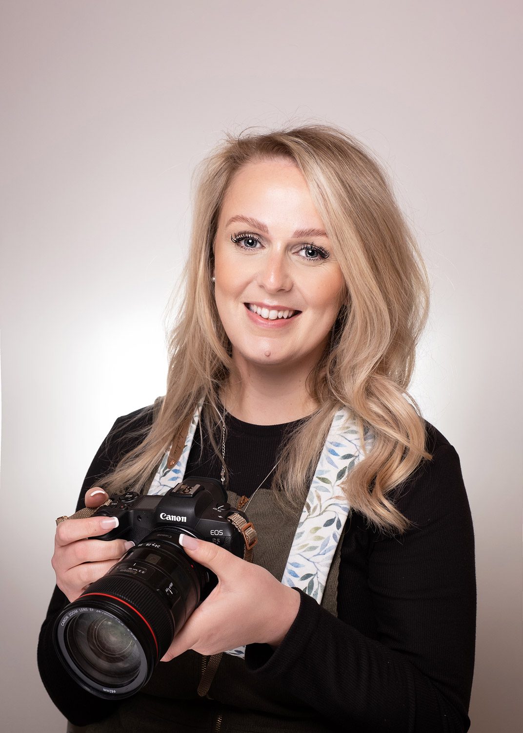 Photographer holding camera at her studio in Surrey