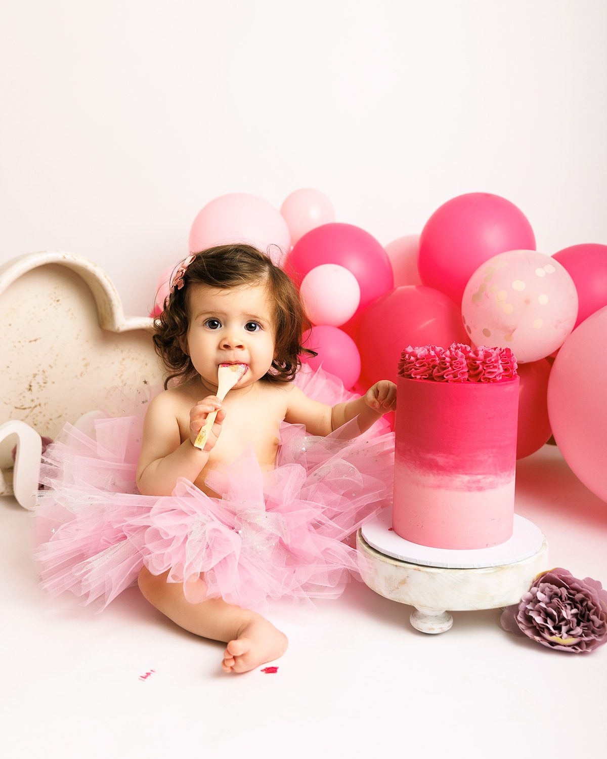 1 year old girl eating cake to celebrate their birthday in woking, Surrey