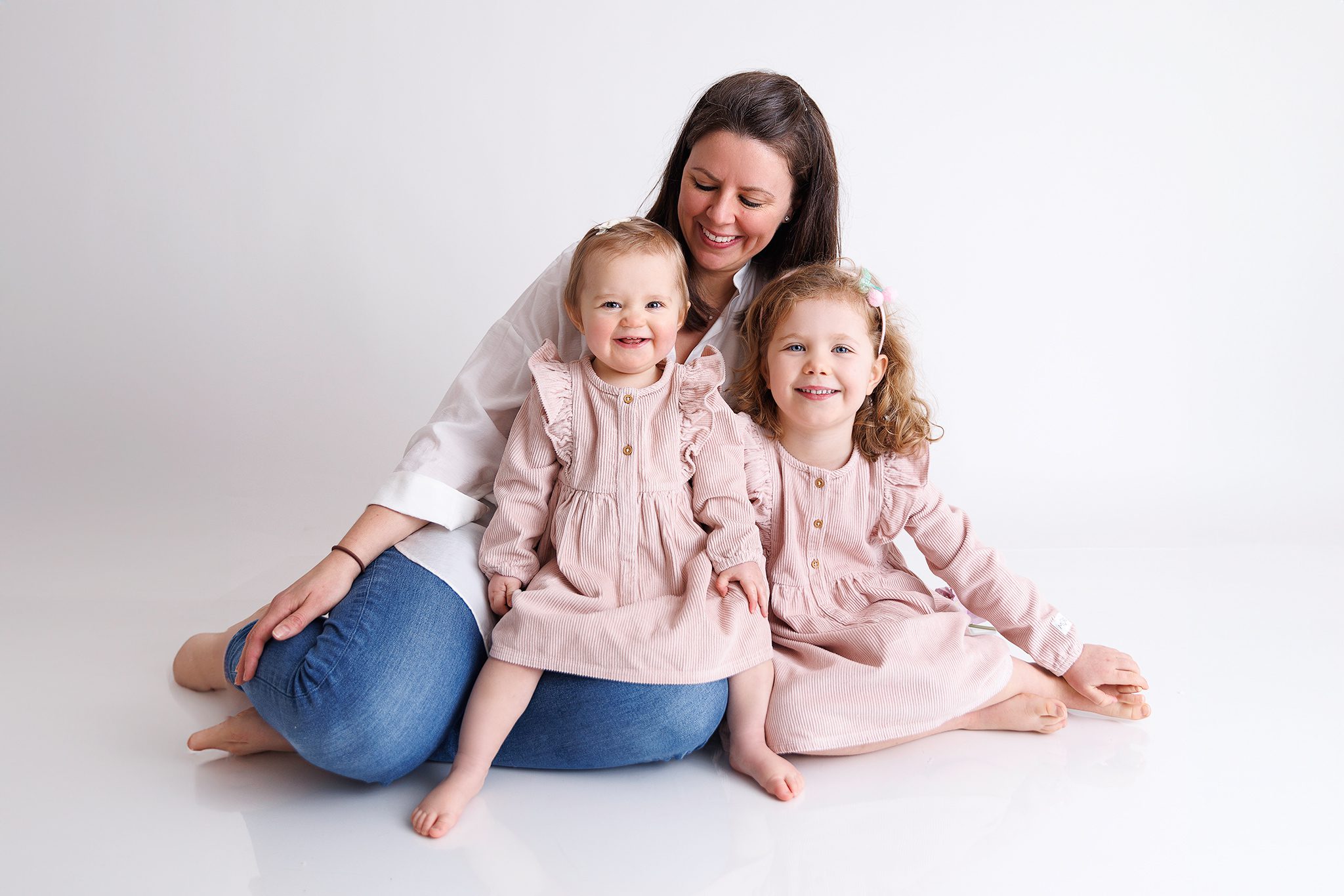 Mother and 2 daughters smiling together for their photoshoot