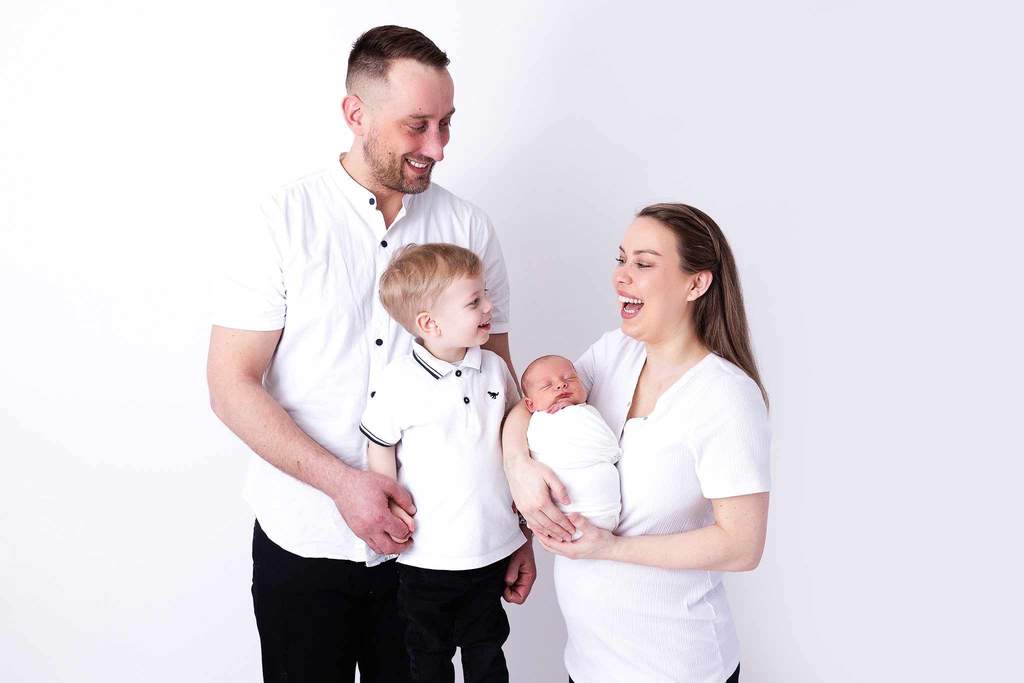 Newborn Family with a toddler laughing in their woking newborn photography session